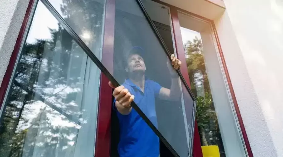 man pulling out a glass window